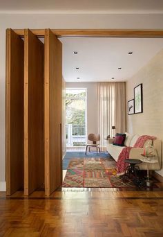 an open door leading to a living room with wood floors and furniture in the background