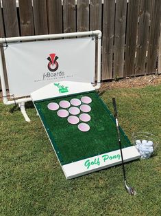 a golf game set up in the grass with balls and tees on it next to a sign