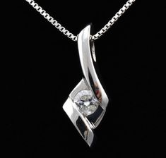 "Features * ITEM #: 4313p * METAL TYPE: 14 Karat White Gold * AVAILABLE IN: Rose Gold, Yellow Gold, White Gold * STONES USED: Diamonds * DIAMOND QTY: 1 * DIAMOND SHAPE: Round * DIAMOND CTW: .125carat * SETTING TYPE: channel set WEIGHT 1.5 gm LONG 17mm with bail Width 6.5mm * READY TO SHIP: in 3-5 Business Days FOR ADDITIONAL QUESTIONS ABOUT THIS PRODUCT: Please feel free to message us. We are quick to respond to all your inquiries. PLEASE choose as \"FAVORITE\" on the right so the item will be a Diamond Jewelry In Diamond White With Tension Setting, Formal Cubic Zirconia Jewelry With Tension Setting, White Cubic Zirconia Jewelry With Tension Setting, Dazzling Diamond Necklace With Single Diamond For Wedding, Wedding Pendant Diamond Necklace With Polished Finish, Silver Diamond Necklace With Tension Setting For Anniversary, White Diamond Jewelry With Polished Finish, Silver Solitaire Necklace With Single Diamond For Wedding, Sterling Silver Diamond Necklace For Wedding