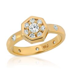 a yellow gold ring with diamonds on the side and an inscription uw in white lettering