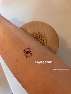 a woman's arm with a playing card tattoo on the left side of her arm