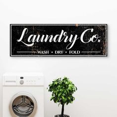 laundry co wash dry fold sign on wall next to washing machine and potted plant