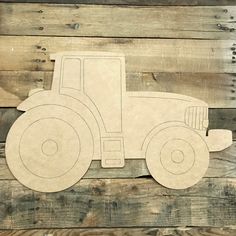 a wooden cutout of a tractor on a wood planks background, with the shape of a tractor