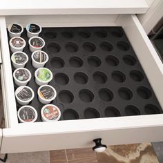 an open drawer with several cups in it