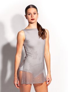 a woman is posing for the camera in her short skirt and tank top with sheer mesh