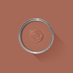 a brown paint can with a long shadow on the wall and a circular object in the middle