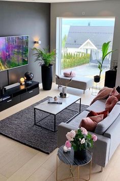 a living room filled with furniture and a flat screen tv mounted to the side of a wall