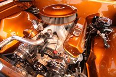 the engine compartment of an orange classic car