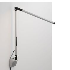 a white wall mounted light with a black cord attached to the back of it's arm