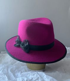 Handmade wool felt fedora hat in stunning magenta pink, finished with a unique handmade lace bow over a black ribbon. Fits an average size 57-58, but it can be adjusted on request to a slightly smaller or larger size. Elegant Adjustable Pink Fedora, Elegant Pink Adjustable Fedora, Pink Brimmed Fedora For Party, Pink Fedora With Curved Brim For Party, Pink Curved Brim Fedora For Party, Pink Party Fedora With Curved Brim, Pink Fedora With Flat Brim For Party, Pink Flat Brim Fedora For Party, Pink Fedora For Party