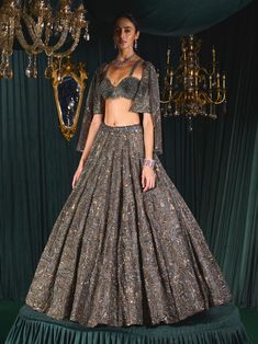 Step into refined elegance with this stunning lehenga that beautifully marries the richness of earthy tones with opulent metallics, adding a touch of royalty and new-age aesthetics. Intricate gunmetal embroidery featuring cut dana and sequins lends a bold, modern edge, while tarnished gold accents evoke a sense of antique grandeur. The lehenga skirt, hand-crafted on organza, showcases a wide mesh of intricate detailing, creating a mesmerizing silhouette. Paired with a stunning jacket and a blouse made from net, this ensemble exudes classic charm and contemporary sophistication. A true masterpiece that celebrates both tradition and modern elegance. Brown Lehenga, Tarnished Gold, Celebrity Plastic Surgery, Lehenga Skirt, Modern Elegance, Earthy Tones, Indian Outfits, Gold Accents, Indian Fashion