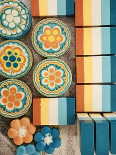 several colorful plates are arranged on the floor next to some cookies and other items that have been placed around them