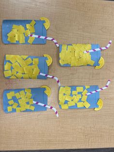 four pieces of paper cut into yellow and blue shapes with straws on the ends