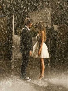 a man and woman standing in the rain under an umbrella with words written on it