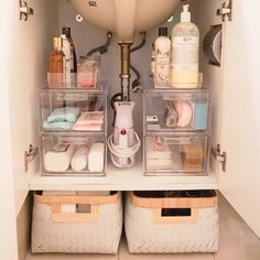 the bathroom is organized with clear plastic bins and containers for soap, lotion, hand sanitizers and other personal care items