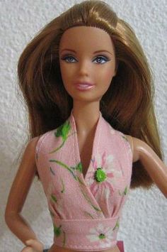 a close up of a barbie doll wearing a pink dress