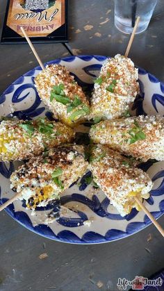 several skewers of food on a blue and white plate next to a book