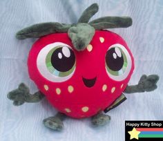 a red stuffed strawberry with big eyes