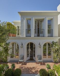 a large white house with lots of windows and balconies on the second floor