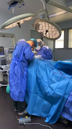 two doctors in scrubs are performing surgery on a patient