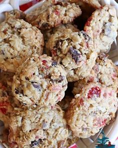 a white bowl filled with oatmeal cookies on top of a red and white table cloth