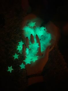 someone is holding out their hand with glowing stars on it