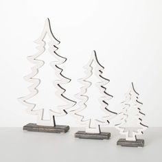 three metal christmas trees sitting next to each other