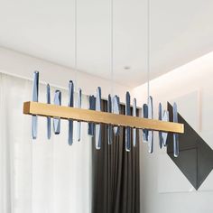 a modern chandelier hanging from the ceiling in a room with curtains and drapes