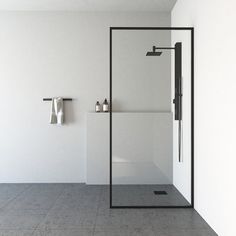 a white bathroom with a glass shower door and towel racks on the wall next to it