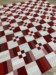 a red and white patchwork quilt is laying on the floor