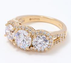 three stone engagement ring with diamond accents on the sides and center stones in gold plating