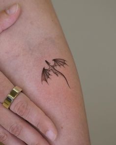 a woman's arm with a small dragon tattoo on the left side of her body