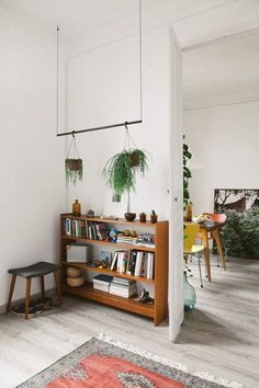 a living room filled with furniture and plants on top of it's book shelves