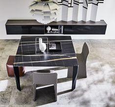 a black and white table sitting on top of a floor next to a shelf filled with vases