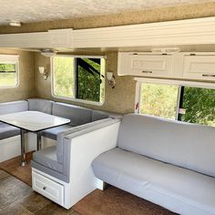 a couch and table in a small living room with white cupboards on the walls