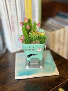 a small potted plant sitting on top of a wooden table next to some books