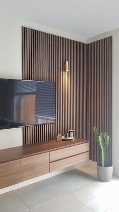 a living room with a large flat screen tv on top of a wooden entertainment center