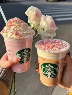 two starbucks drinks with whipped cream and flowers