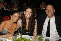 two women and a man sitting at a dinner table