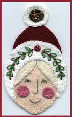 a christmas ornament with a woman's face on it and holly leaves