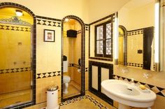 a bathroom with yellow and black tiles on the walls