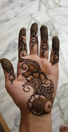 a person's hand with henna tattoos on it