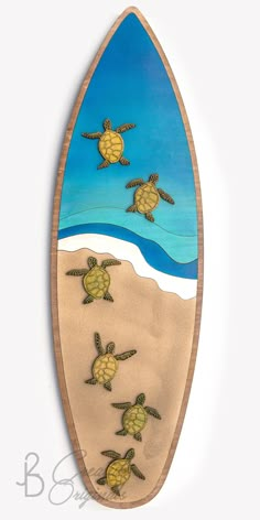 a surfboard with sea turtles painted on it's side and sand underneath the board