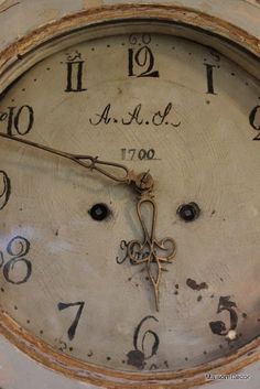 an old clock with writing on the face and numbers painted on it's sides