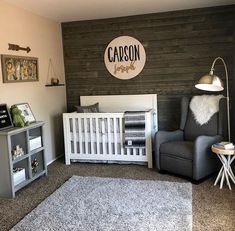 a baby's room with a gray chair, white crib and wooden wall