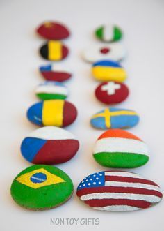 colorful rocks with flags painted on them are arranged in a straight line to form the shape of a christmas tree