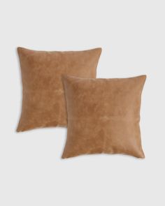 two brown pillows sitting next to each other