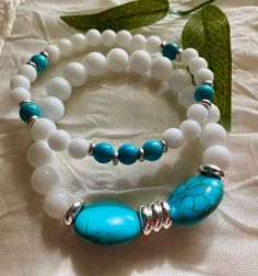 * This a definitely a "summery piece of jewelry"  * It features Turquoise stones in the oval shape as  focal, White Ceramic beads and silver details.  * It's a double strand stretchy bracelet and it measures 7 inches.  * I want you to know I strung all my stretchy bracelets with a double cord for durability and strength.  * Make sure you know to roll your stretchy bracelet in and out of your wrist, every time you wear it to avoid stretching those cords.  * I offer you free domestic shipping, and for your convenience all my orders ship with a tracking number.  * Please note that photos are taken in natural light as accurately as possible and a slight variation in sizes of handmade beads is unavoidable. * I appreciate your business and I hope you can see the attention to details I put when d Turquoise Stretch Bracelet With Colorful Beads As A Gift, Turquoise Stretch Bracelet With Natural Stones For Gift, Turquoise Stretch Bracelet With Natural Stones As Gift, Turquoise Stretch Bracelet With Gemstone Beads As Gift, Turquoise Gemstone Beads Stretch Bracelet As Gift, Turquoise Howlite Beaded Bracelets As A Gift, Handmade White Oval Bracelet, Handmade Oval White Bracelet, Adjustable White Bracelet With Oval Beads