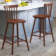 two wooden stools sitting in front of a kitchen island