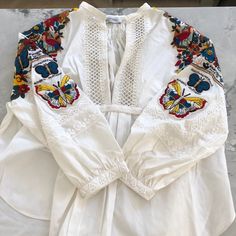 The Embroidery And Beading On This Shirt Is Incredible And A True Conversion Piece. Size 2, But Very Loose Fitting. White V-neck Blouse With Intricate Embroidery, White V-neck Top With Intricate Embroidery, Summer Embellished Multicolor Embroidered Top, White V-neck Blouse With Embroidered Sleeves, Bohemian Embellished Embroidered Top For Spring, White Long Sleeve Top With Intricate Embroidery, Traditional Embellished Tops For Spring, White Embellished Long Sleeve Tops, White Long Sleeve Top With Embroidered Neckline